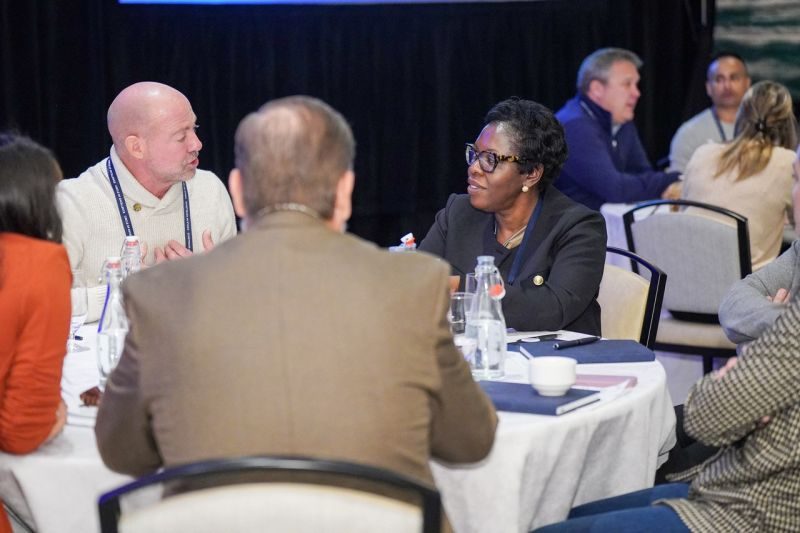 The Goddard School leadership and franchisees in discussion at a table during franchise convention. 